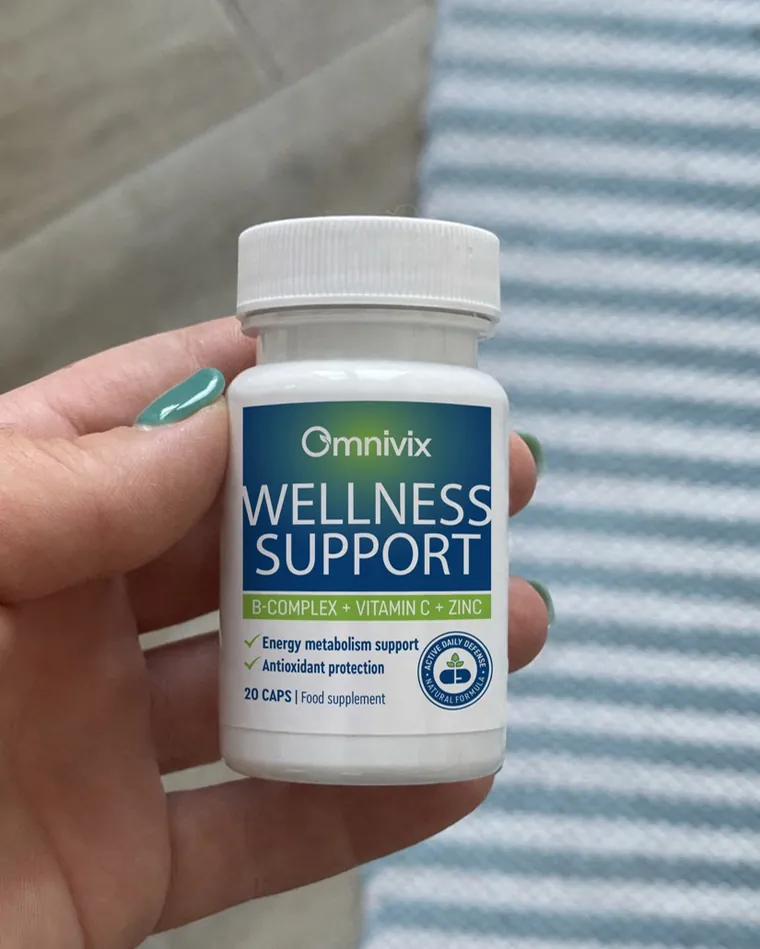 Mano che tiene un flacone di Omnivix Wellness Support